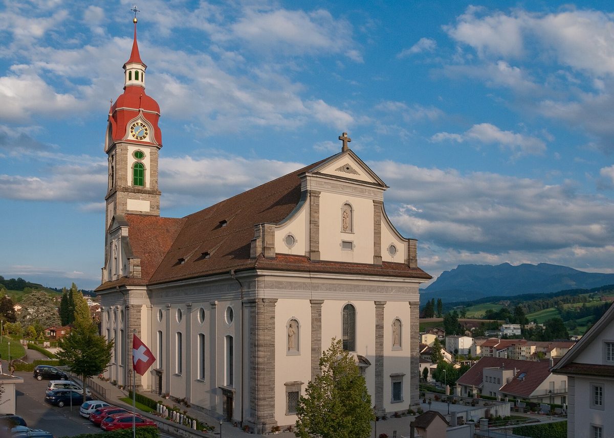 Die spätbarocke Pfarrkirche St. Mauritius in Ruswil, rechts der Pilatus