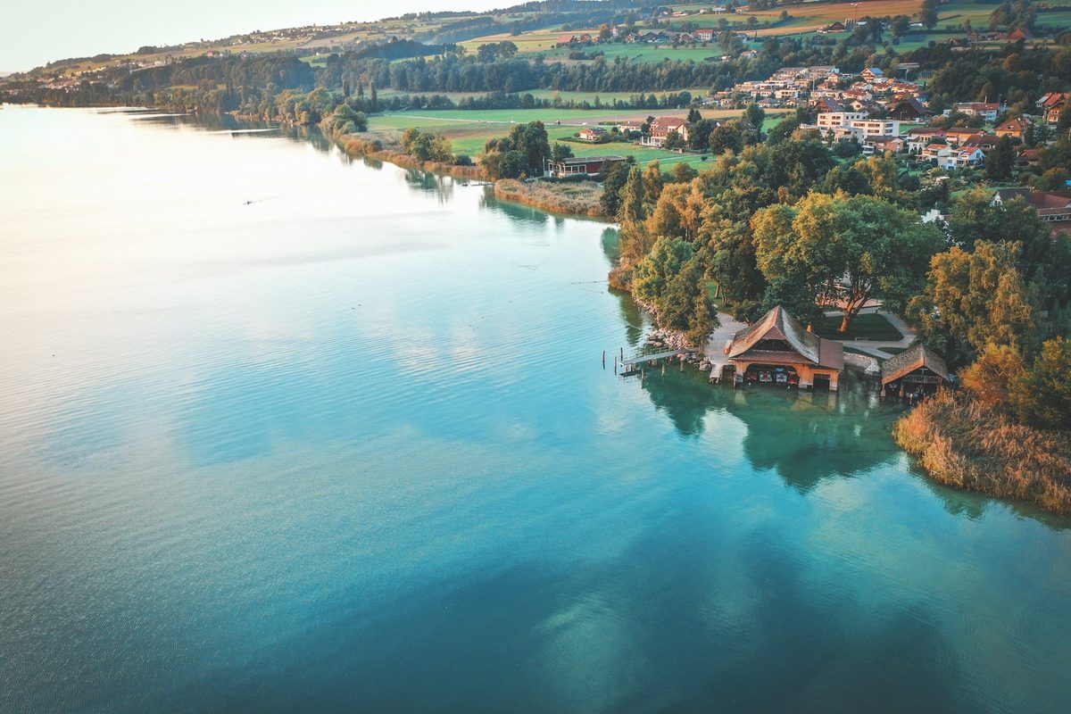 Der Sempachersee bei Sonnenaufgang mit Bootshaus und dem Städtli Sempach am Hang