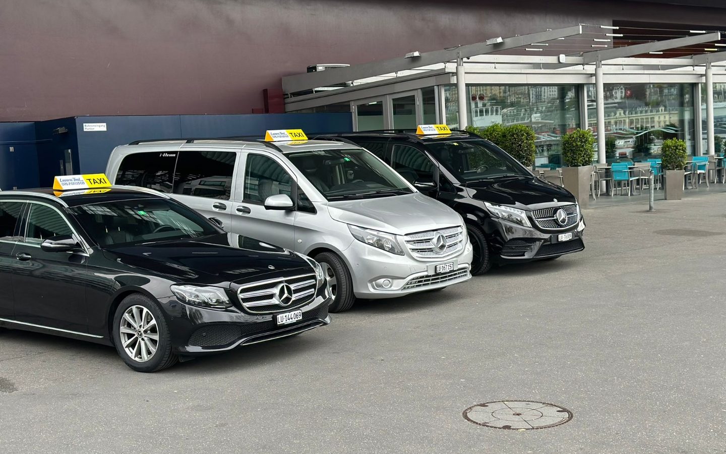 Drei Fahrzeuge von Luzerner Taxi nebeneinander: Mercedes E-Klasse, silberner Kleinbus und schwarze V-Klasse